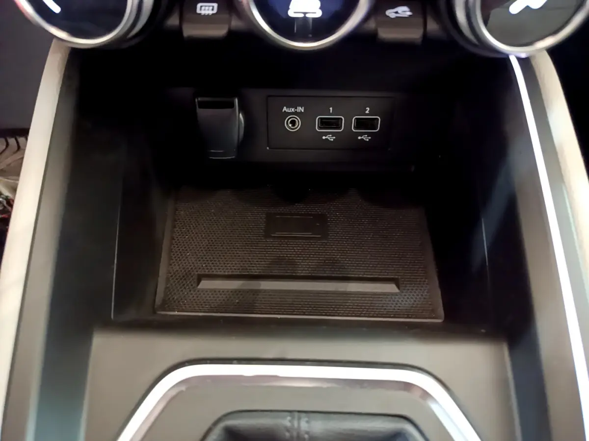 Gros plan sur la console centrale noire de la Renault Clio Initiale Paris E-TECH 140 avec ports USB et prise Aux-IN.