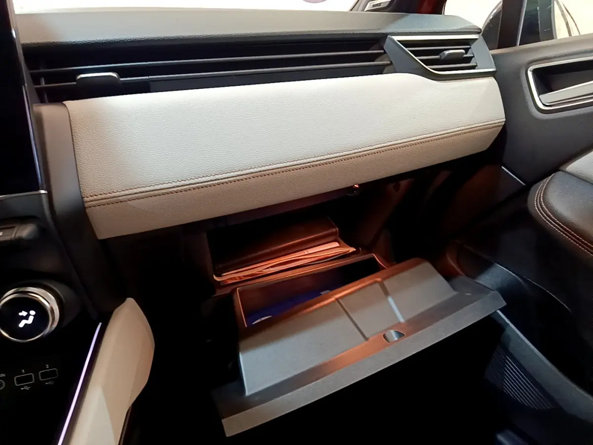 Gros plan sur la boîte à gants beige ouverte côté passager de la Renault Clio Initiale Paris orange 2021.