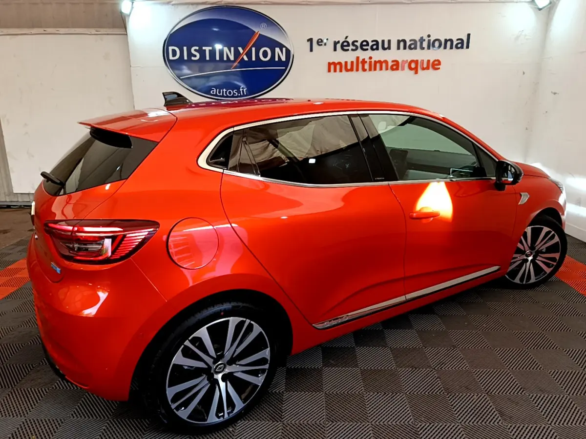 Renault Clio Initiale Paris E-TECH 140 orange vue de côté droit arrière, jantes alliage et vitres teintées visibles