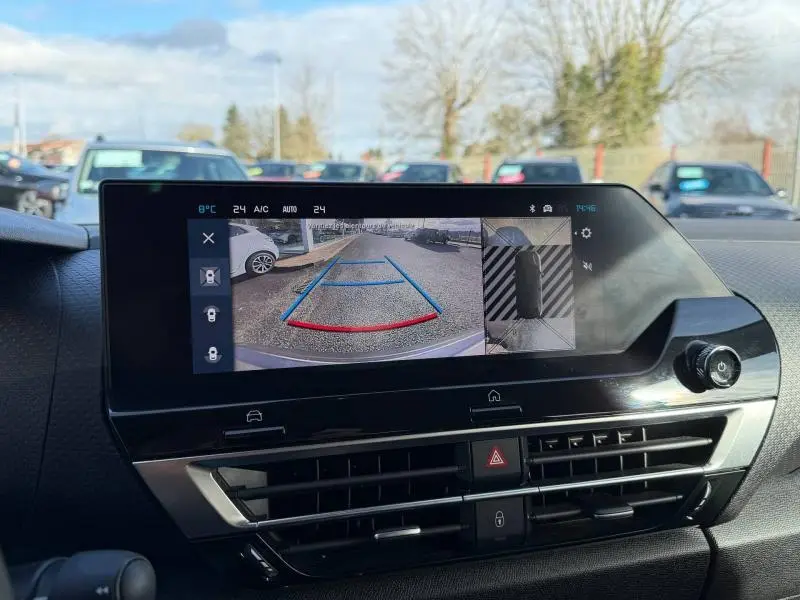 Écran central du tableau de bord du Citroën C4 2024 montrant la caméra de recul avec guidage coloré bleu et rouge.