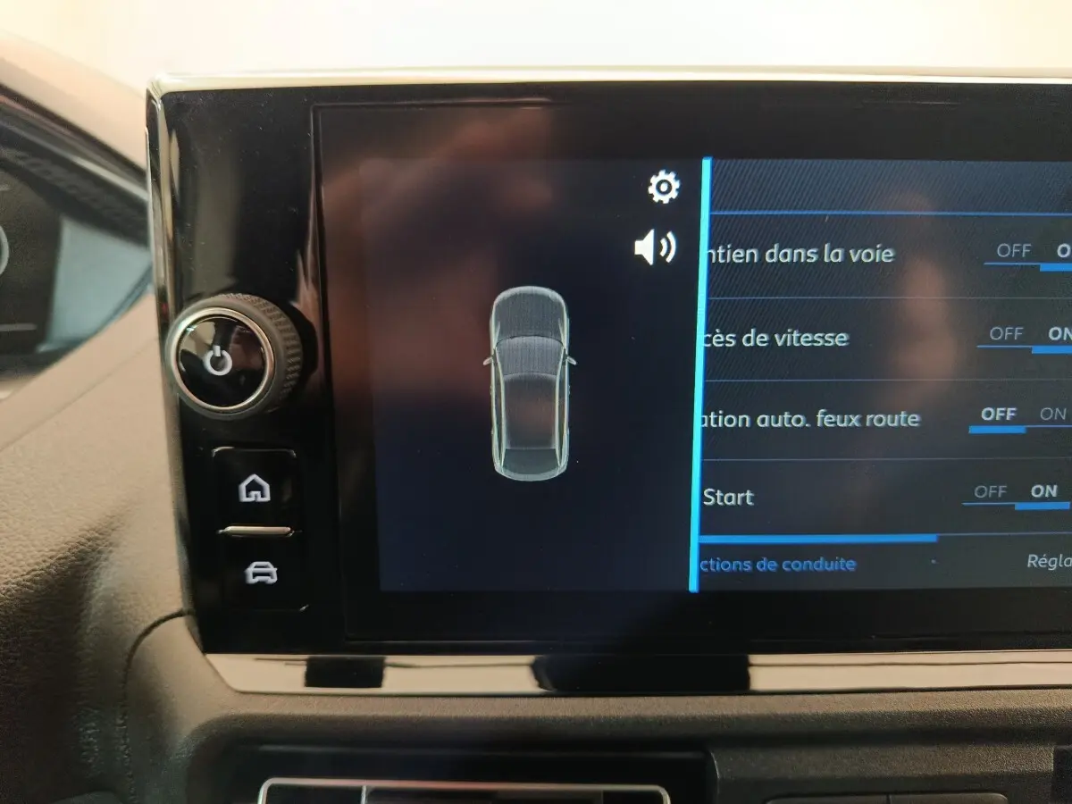 Écran tactile intérieur montrant les réglages d’aide à la conduite du Peugeot Partner blanc, vue rapprochée du tableau de bord.