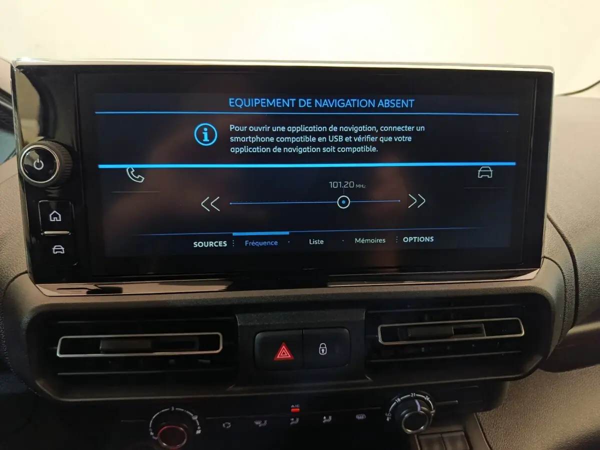 Vue rapprochée de l’écran tactile central du Peugeot Partner blanc, affichant un message d’équipement de navigation absent.