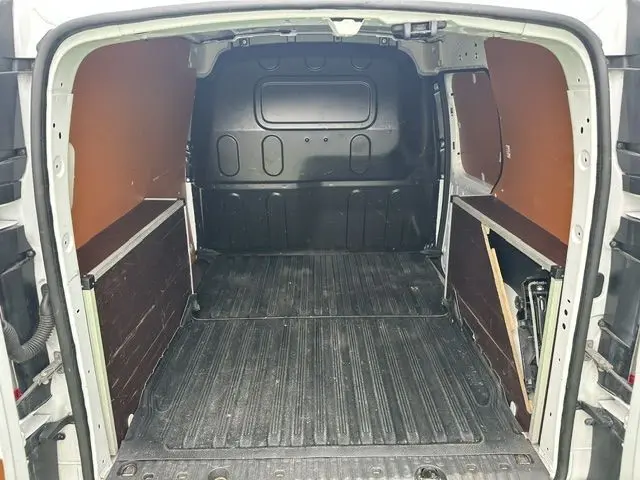Vue de l'intérieur arrière du Renault Kangoo blanc 2020, montrant l'espace de chargement avec revêtement en bois sur les côtés.
