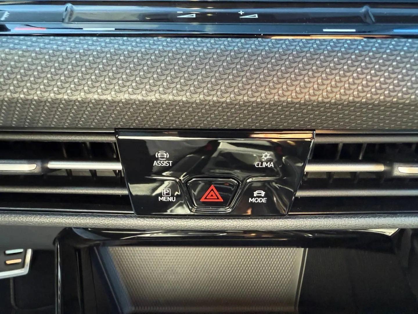 Détail du tableau de bord noir avec commandes d'assistance, climatisation et mode sur Volkswagen Golf 2024.