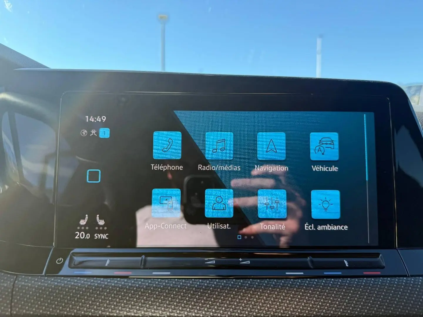 Écran tactile central de la Volkswagen Golf 2024 affichant le menu principal avec icônes bleues, vue de face.