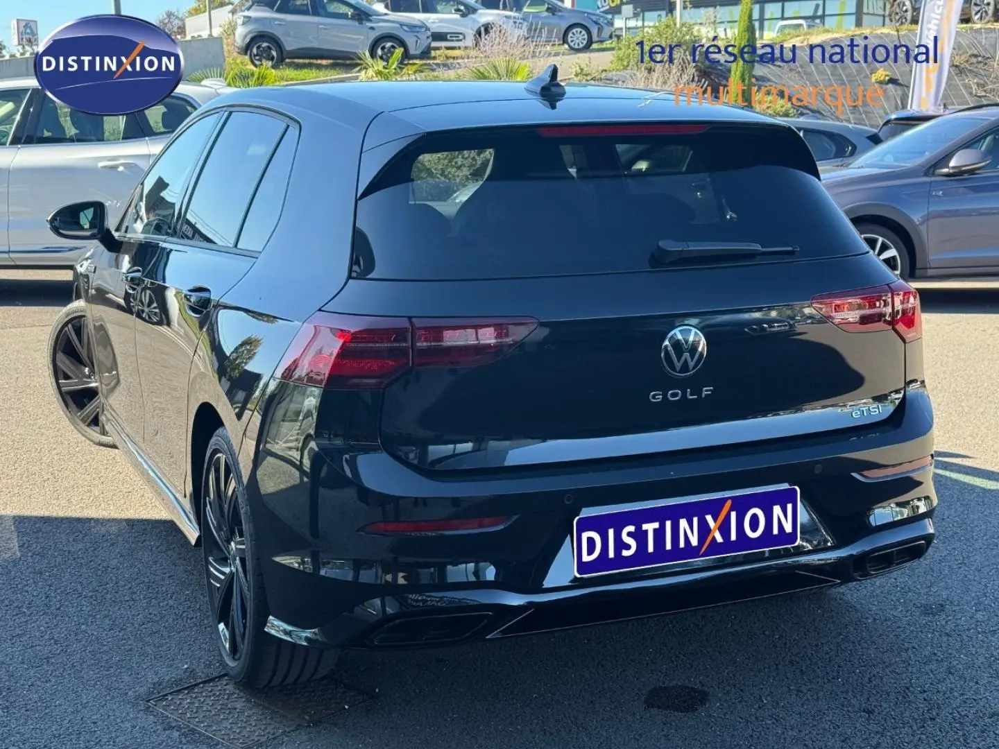 Vue 3/4 arrière droite d'une Volkswagen Golf 1.5 eTSI R-Line noire Grenadilla métallisée avec jantes alu noires.