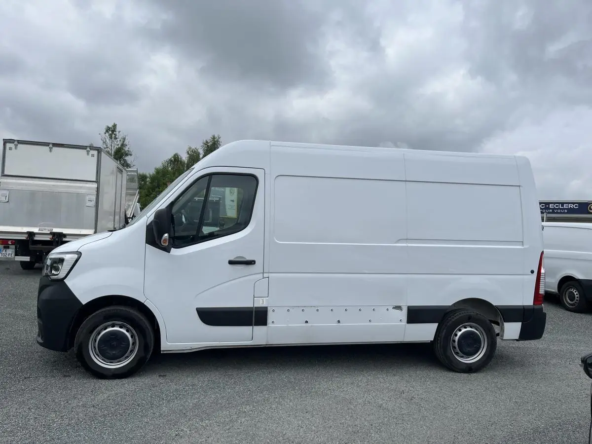 Renault Master blanc vu de profil côté gauche, fourgon utilitaire avec protections latérales noires et jantes tôles.