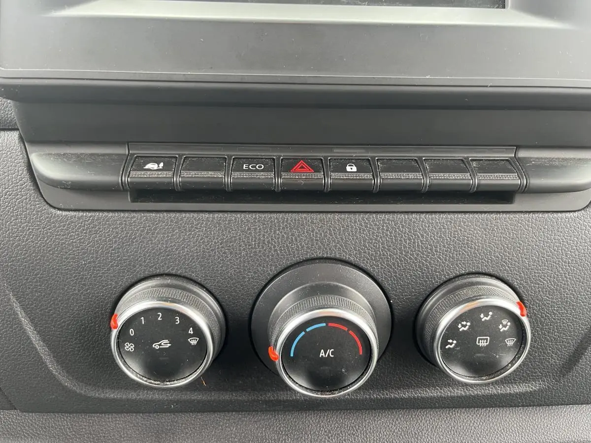 Commandes de climatisation et boutons de fonction du tableau de bord du Renault Master blanc, vue rapprochée.