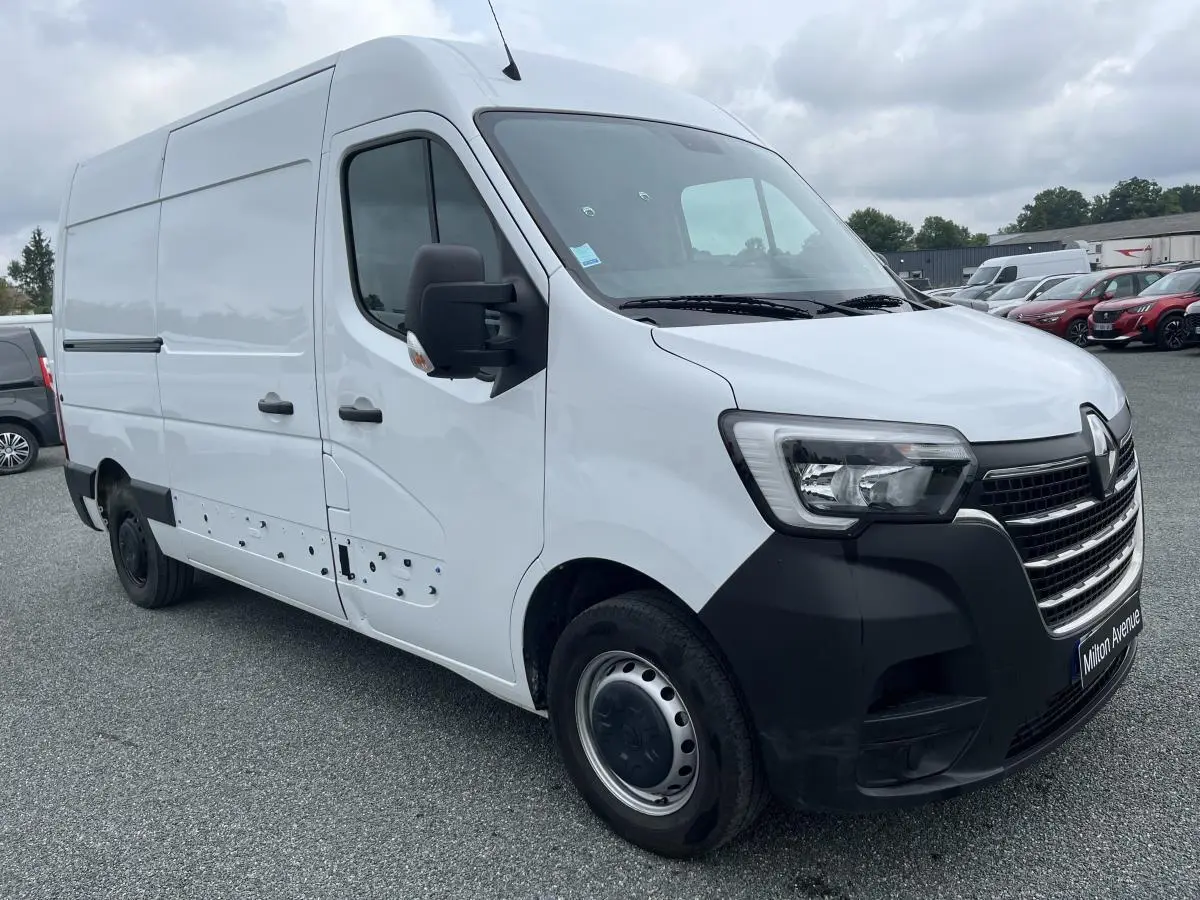 Renault Master blanc en vue 3/4 avant droit, fourgon utilitaire avec pare-chocs noir et jantes tôles 16 pouces.