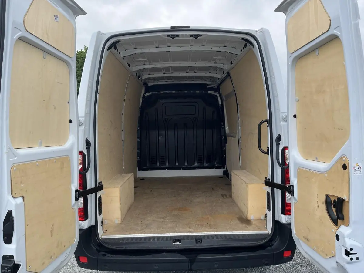 Vue arrière ouverte du Renault Master blanc 2022 avec intérieur de chargement en bois complet et anneaux d'arrimage visibles.