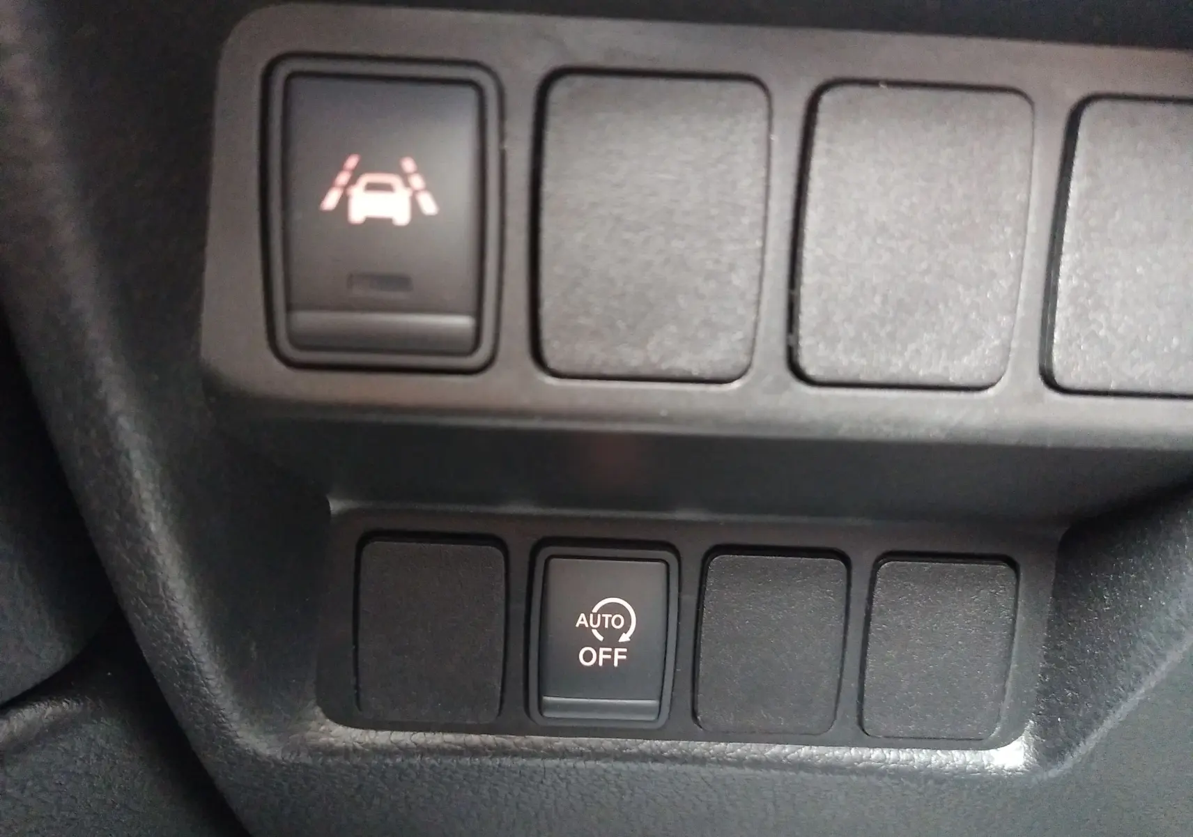 Gros plan sur les boutons de commande du tableau de bord du Nissan Qashqai blanc, avec activation du régulateur automatique.