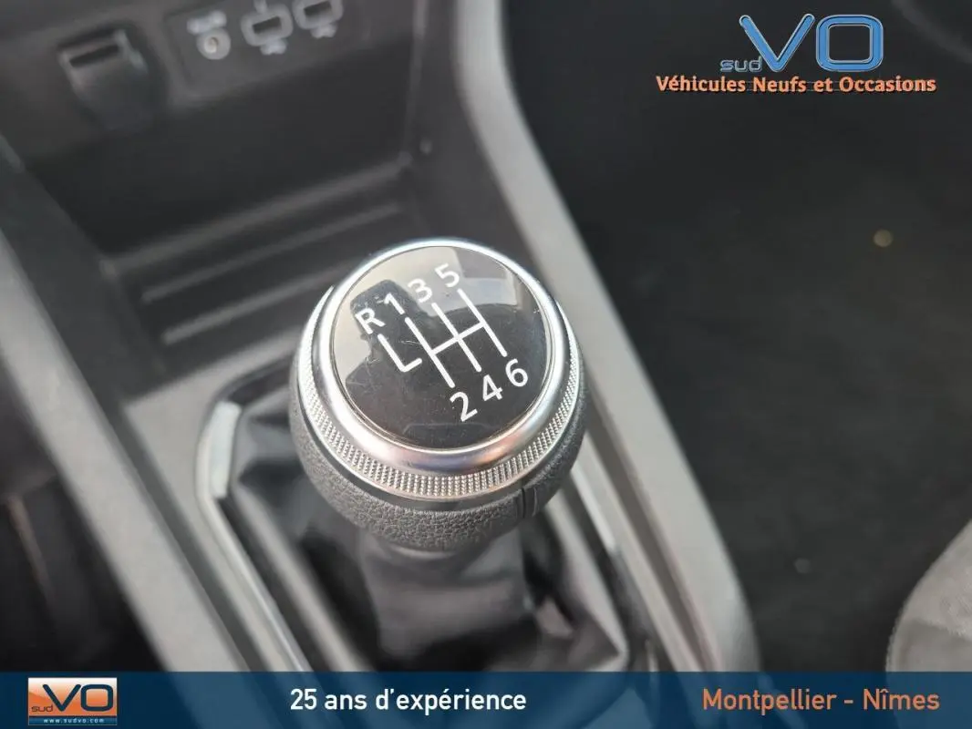 Gros plan sur le levier de vitesses manuel noir de la Renault Clio V TCe 90 Equilibre 2023, essence, intérieur sombre.