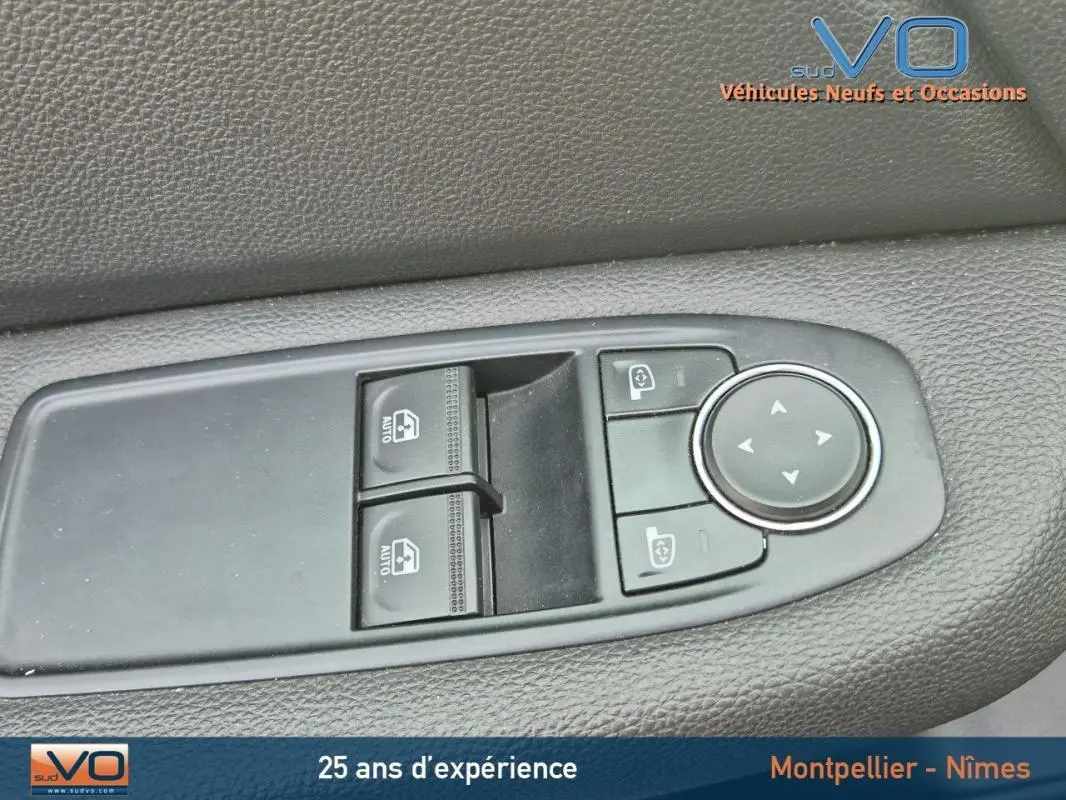 Gros plan sur les commandes de lève-vitres et rétroviseurs côté conducteur de la Renault Clio V TCe 90 noire 2023.