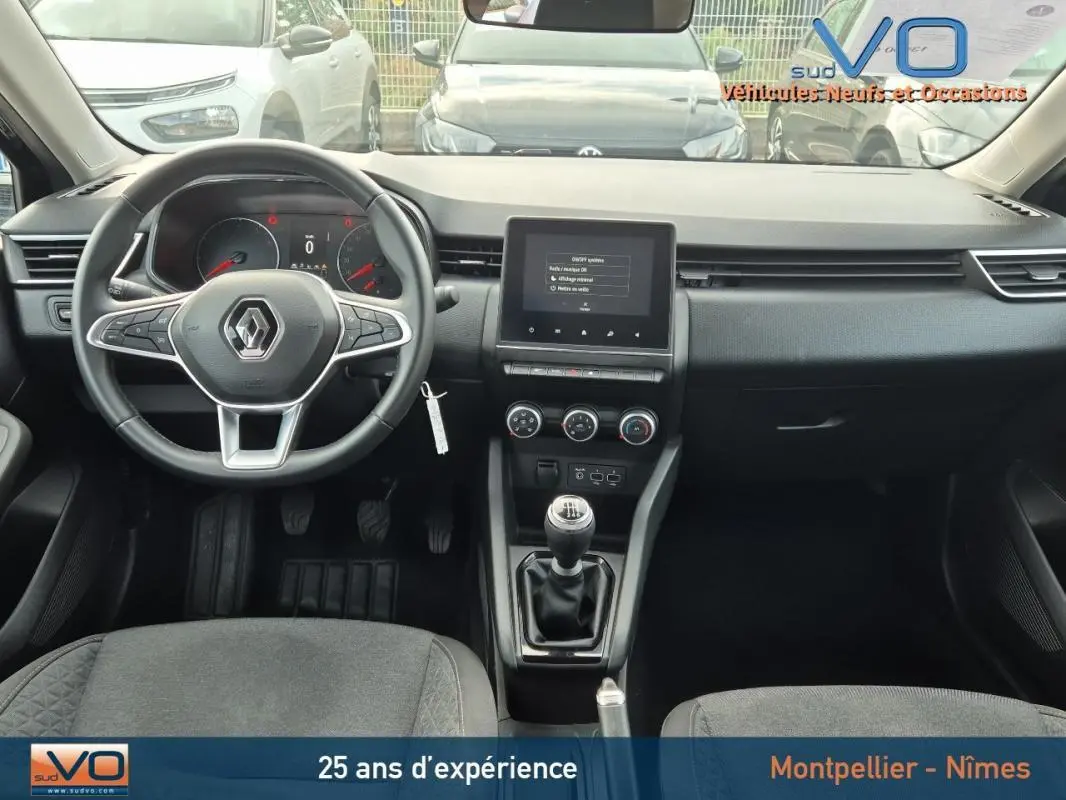 Vue intérieure frontale du tableau de bord et volant noir de la Renault Clio V TCe 90 Equilibre 2023 avec boîte manuelle.