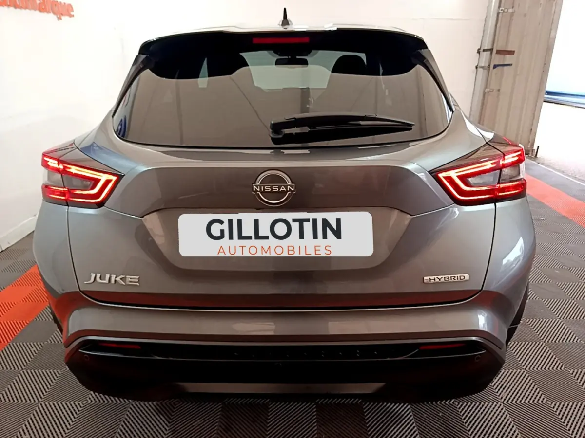 Vue arrière du Nissan Juke Hybrid gris foncé 2023 avec feux LED caractéristiques et logo Nissan visible.