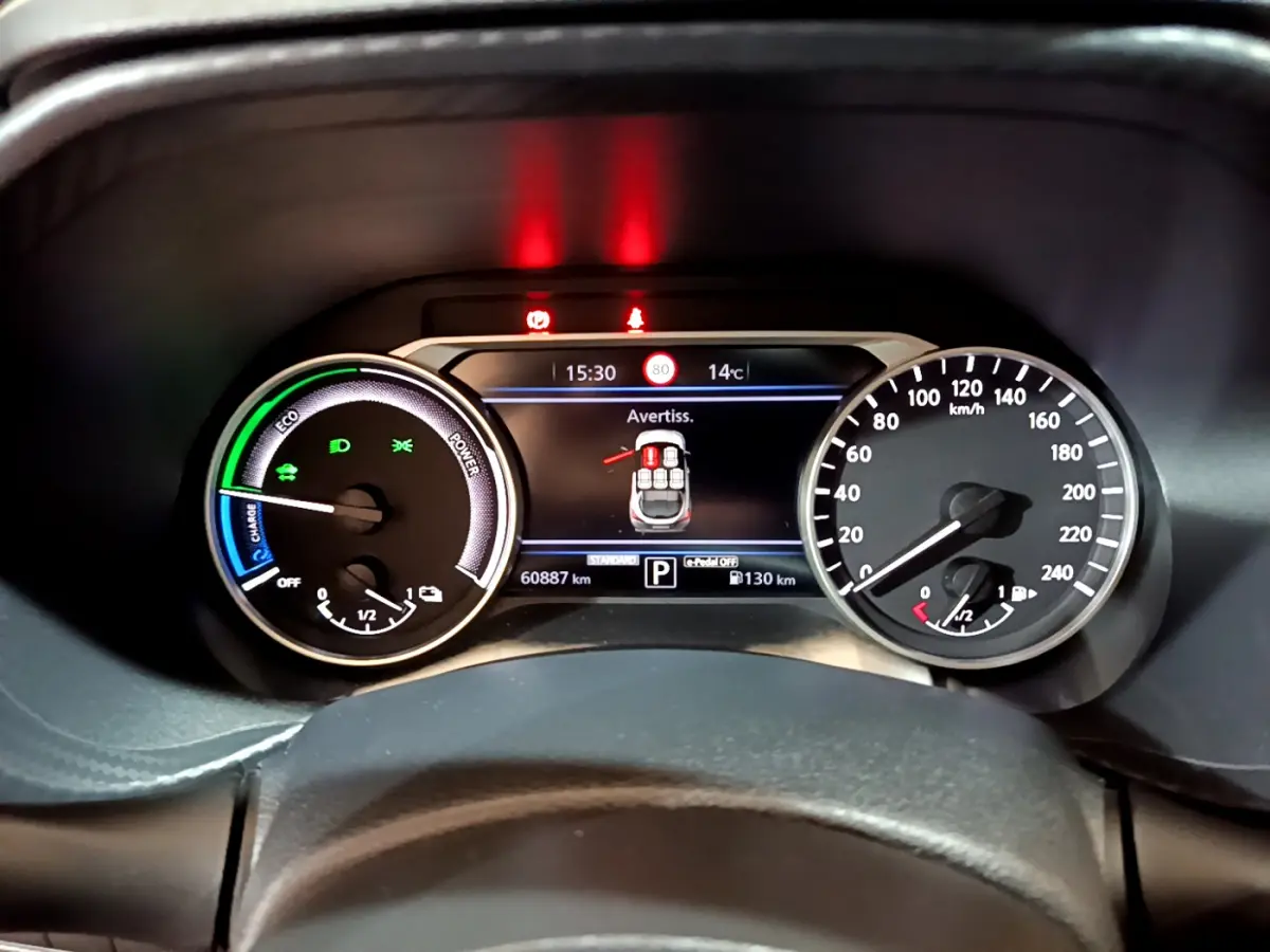 Gros plan sur le combiné d'instruments du Nissan Juke Hybrid 143 Business+, affichage digital et compteurs analogiques.