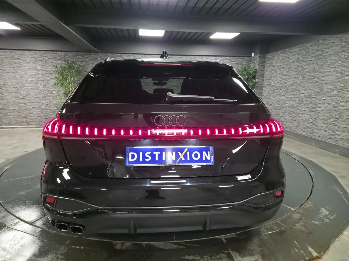 Vue arrière d'une Audi A5 Avant noire 2025 avec feux arrière LED continus et double sortie d'échappement chromée.