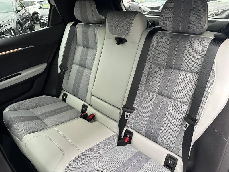 Vue intérieure des sièges arrière gris clair et tissu à motifs du Renault Scenic E-Tech Electric 2025, avec ceinture de sécurité noire.