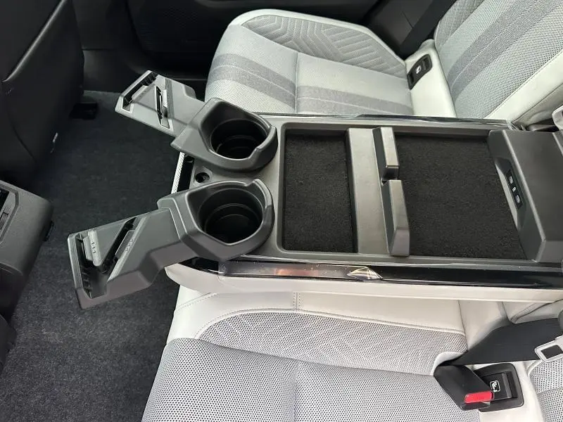 Vue rapprochée de l'accoudoir central arrière gris clair avec porte-gobelets déployés dans le Renault Scenic E-Tech 2025.