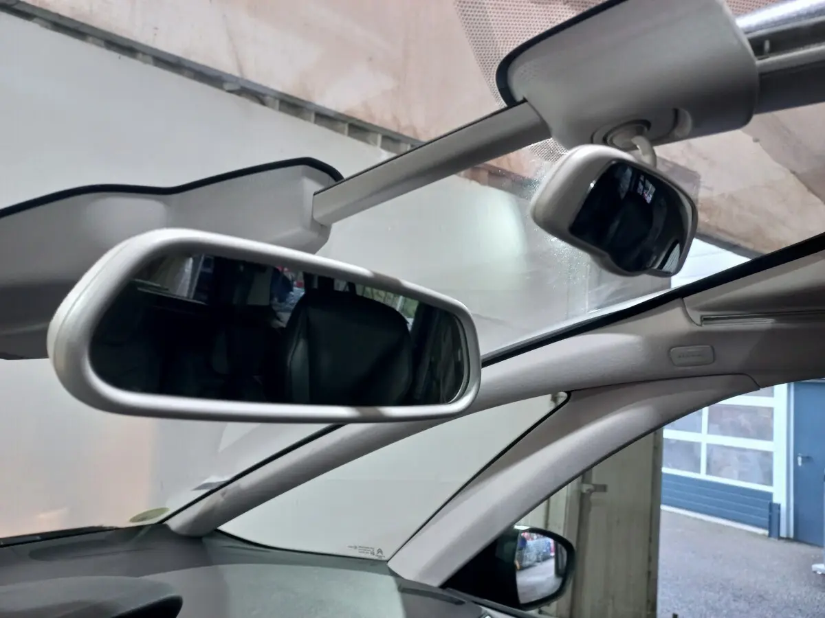 Vue intérieure du pare-brise panoramique et du rétroviseur central d'un Citroën Grand C4 SpaceTourer noir.