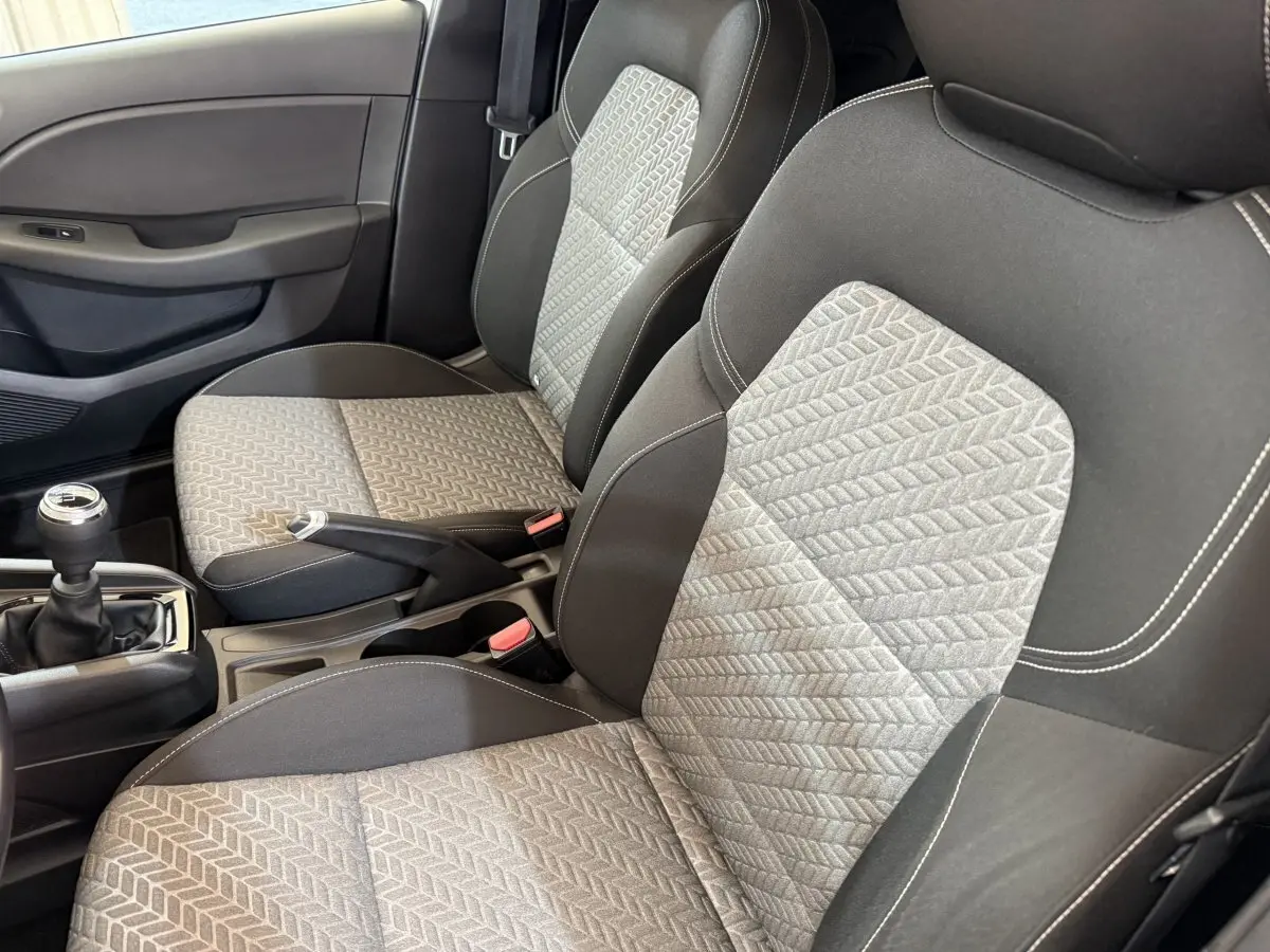 Gros plan sur les sièges avant gris et noirs de la Renault Clio Business TCe 100 GPL avec levier de vitesse manuel visible.