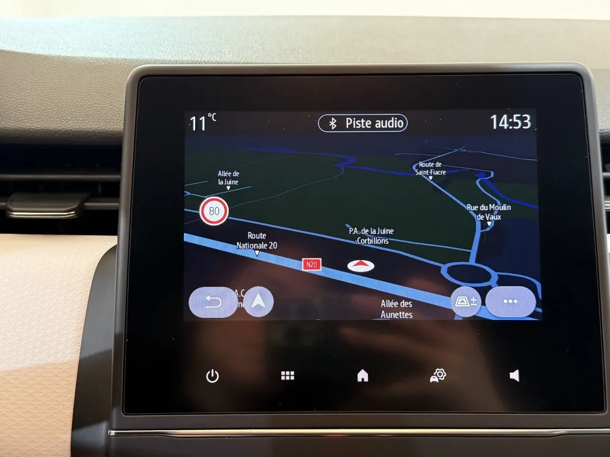 Écran tactile central de navigation 3D affichant une carte routière dans l'habitacle d'une Renault Clio blanche.