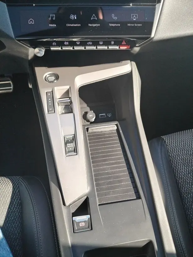 Vue rapprochée de la console centrale intérieure de la Peugeot 308 SW Hybrid 145 GT avec commandes de boîte auto et écran tactile.