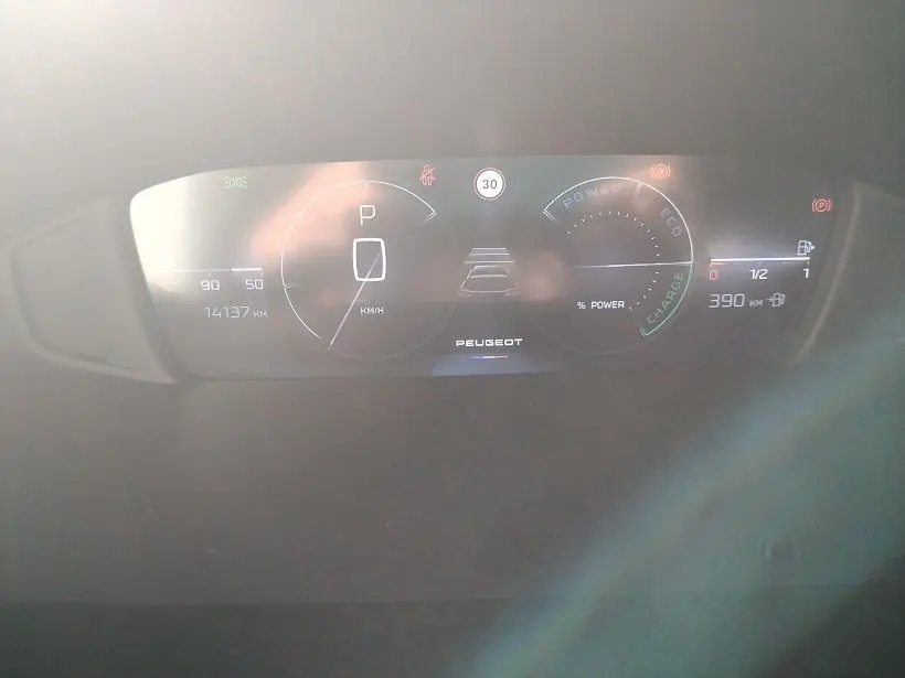 Tableau de bord numérique du Peugeot 308 SW Hybrid 145 GT, affichant vitesse, autonomie et indicateurs d'énergie.