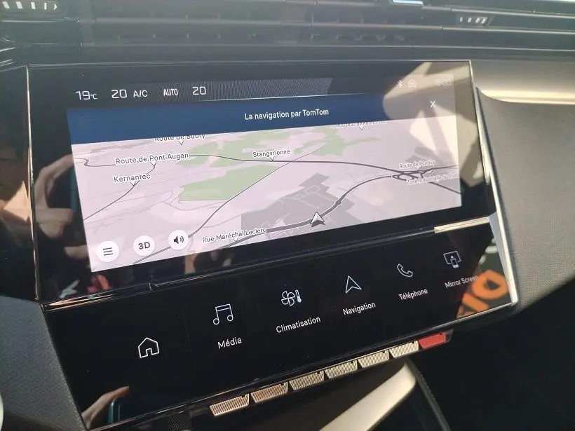 Écran tactile central de la Peugeot 308 SW Hybrid 145 GT montrant la navigation TomTom avec commandes tactiles en bas.