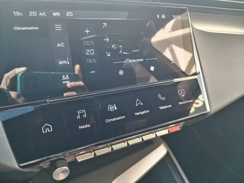 Écran tactile central du tableau de bord de la Peugeot 308 SW Hybrid 145, affichant les réglages de climatisation.
