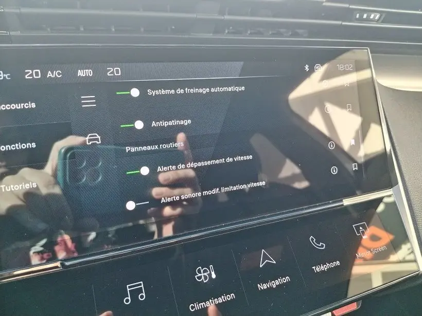 Écran tactile intérieur du Peugeot 308 SW Hybrid 145 GT montrant les réglages d’aides à la conduite.