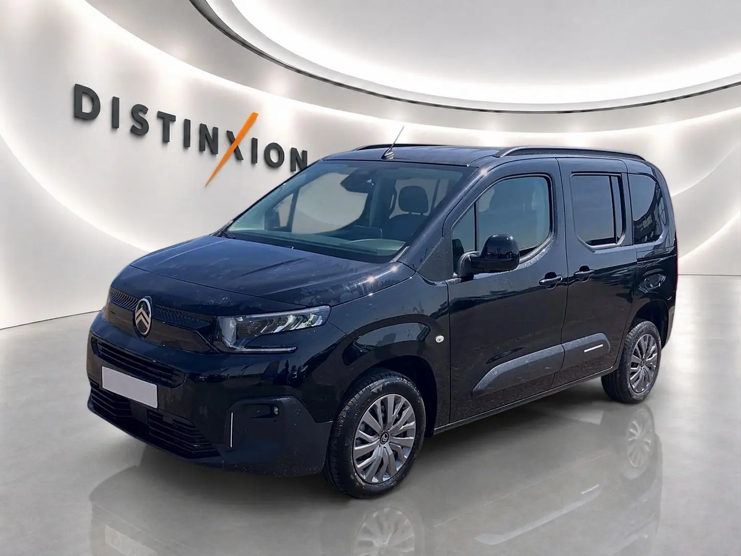 Vue 3/4 avant droit d'un Citroën Berlingo noir 2026 avec barres de toit et jantes alu visibles.