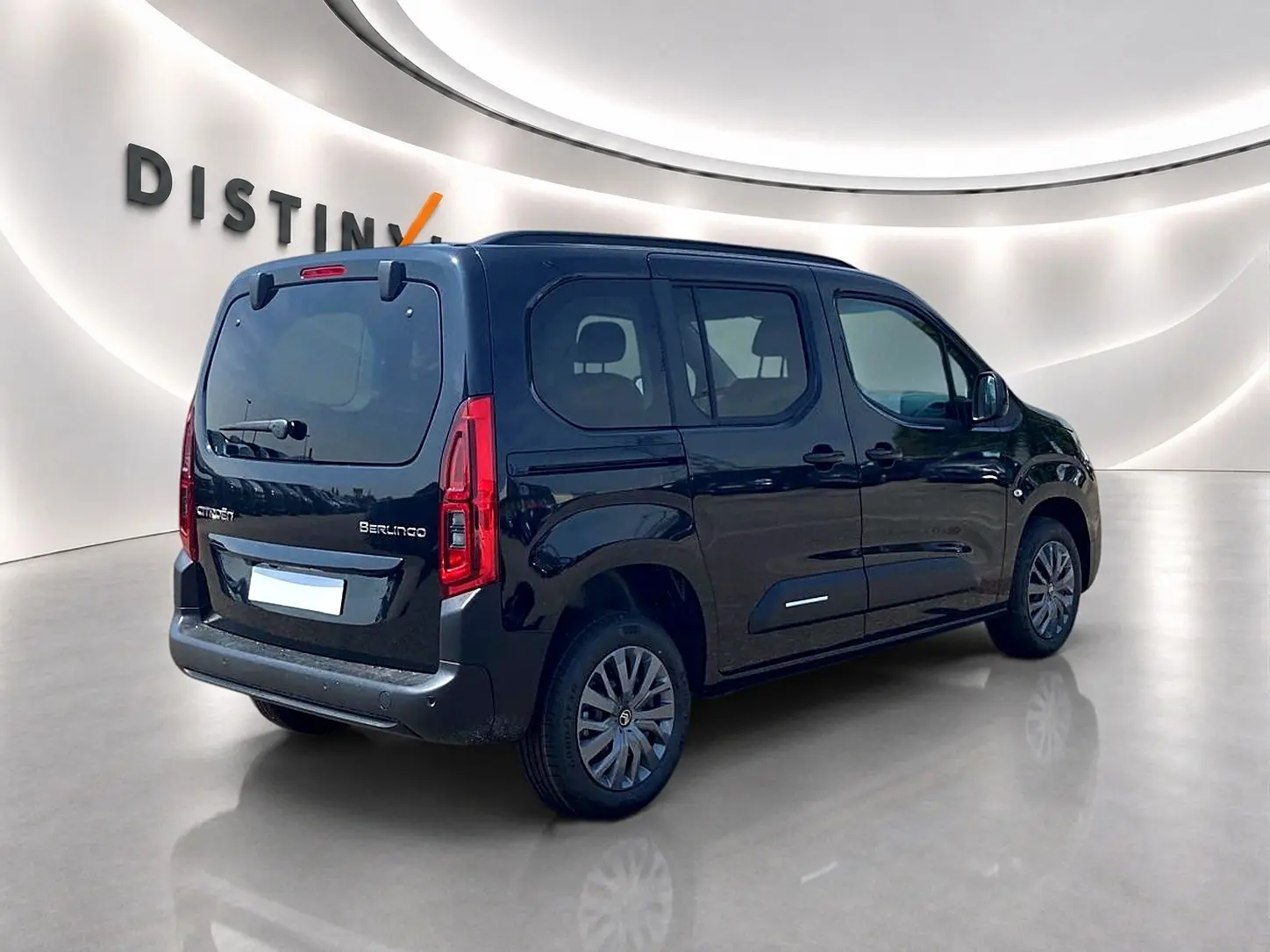 Vue 3/4 arrière droite d'un Citroën Berlingo noir 2026 avec barres de toit et vitres teintées.