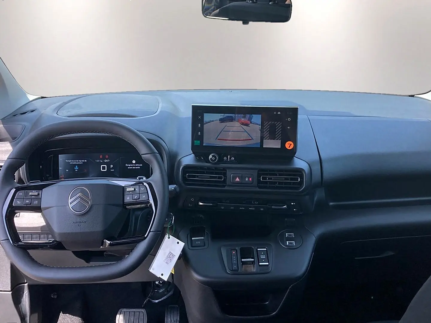Vue intérieure du tableau de bord noir du Citroën Berlingo 2026 avec écran tactile et volant multifonction.