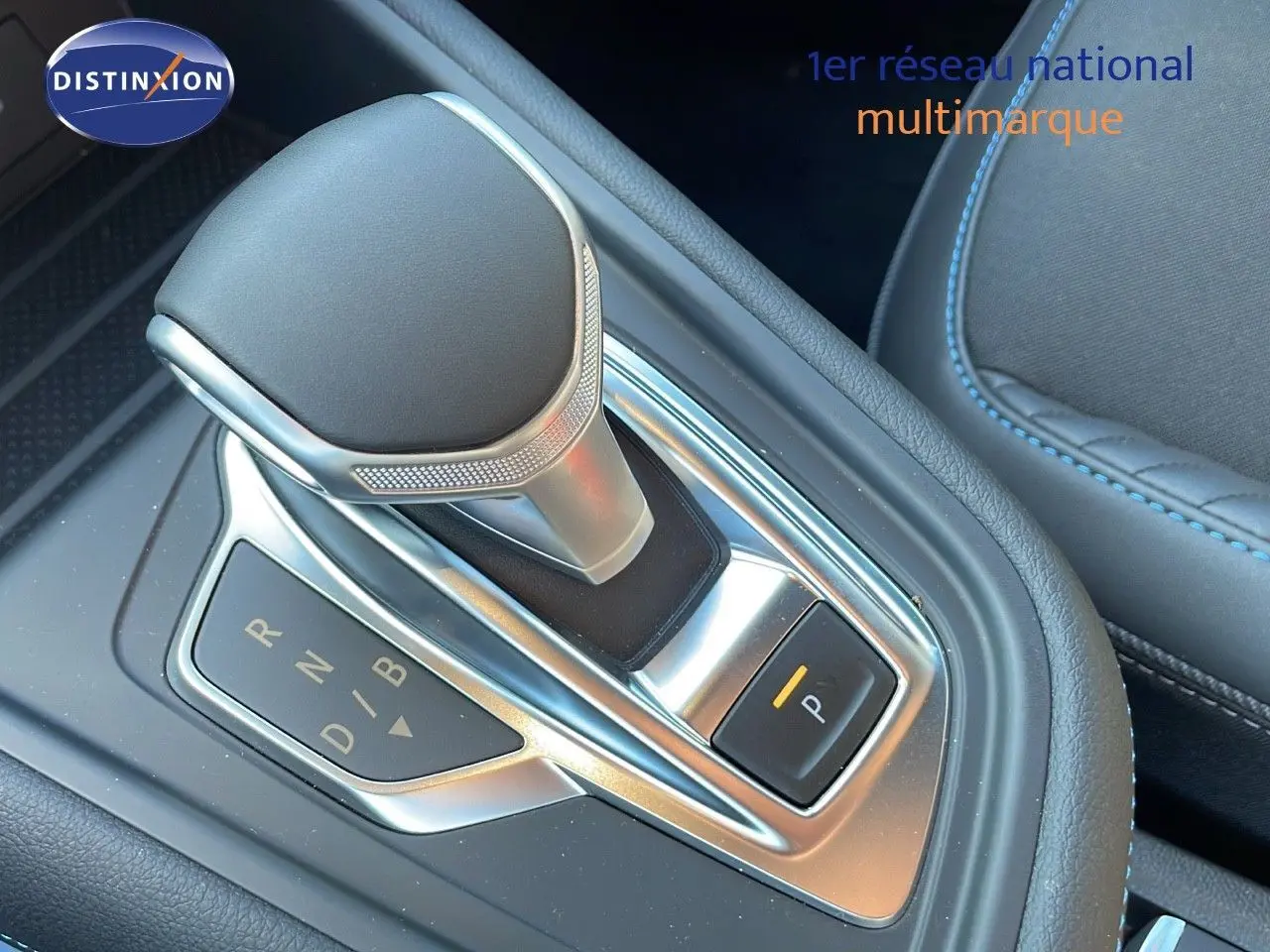 Le levier de vitesses automatique du Renault Captur E-Tech hybride 2025, avec finition cuir noir et surpiqûres bleues.