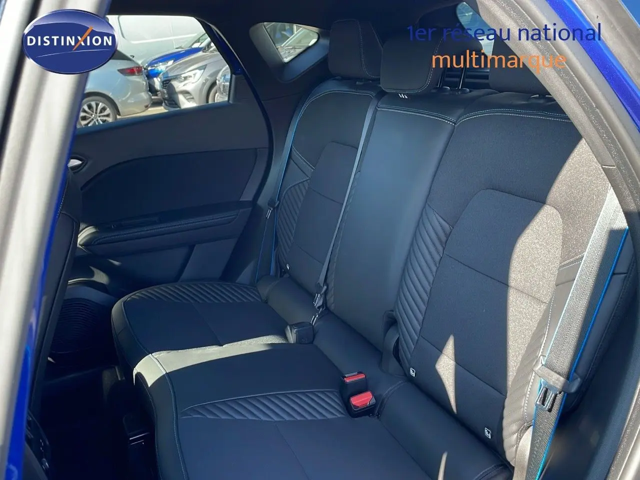 Vue intérieure côté droit sur la banquette arrière en cuir noir avec surpiqûres bleues du Renault Captur E-Tech 2025.