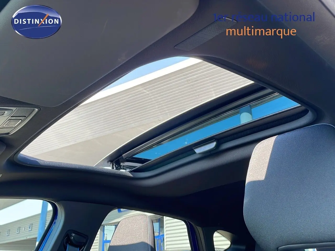 Toit ouvrant panoramique ouvert vu de l'intérieur du Renault Captur 2025 bleu iron metal avec toit noir.