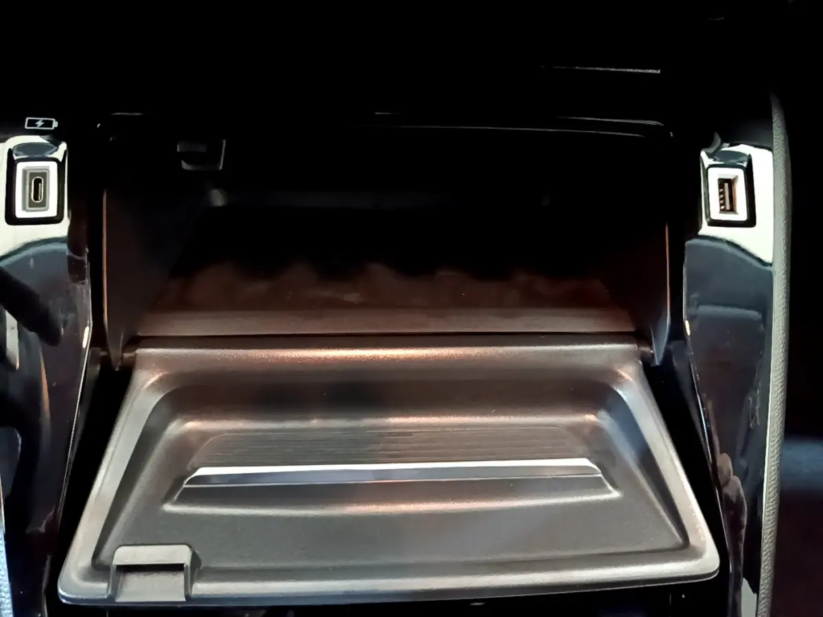 Gros plan sur la console centrale noire du Peugeot 208 2022 avec ports USB avant et arrière visibles.