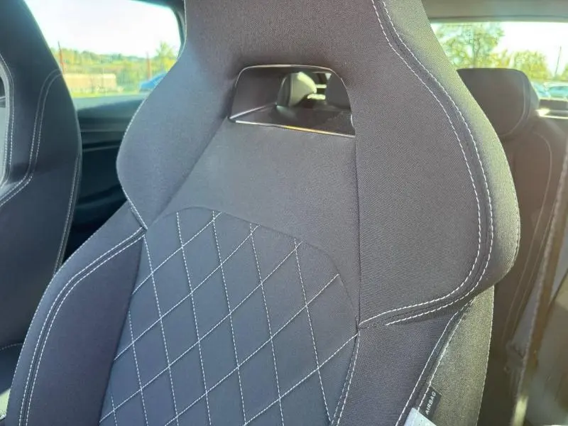 Gros plan sur le siège avant sport noir avec surpiqûres blanches du Skoda Karoq 2025 gris perle spéciale.
