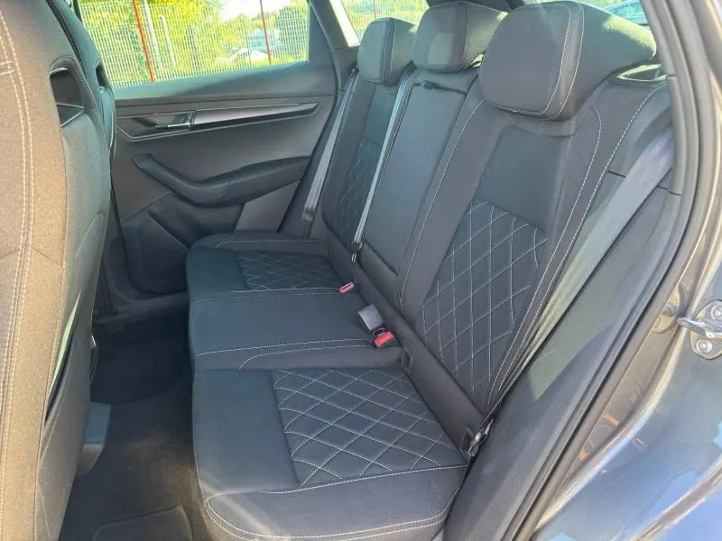 Vue côté droit de la banquette arrière en tissu noir avec surpiqûres sur un SKODA KAROQ gris 2025 Sportline.