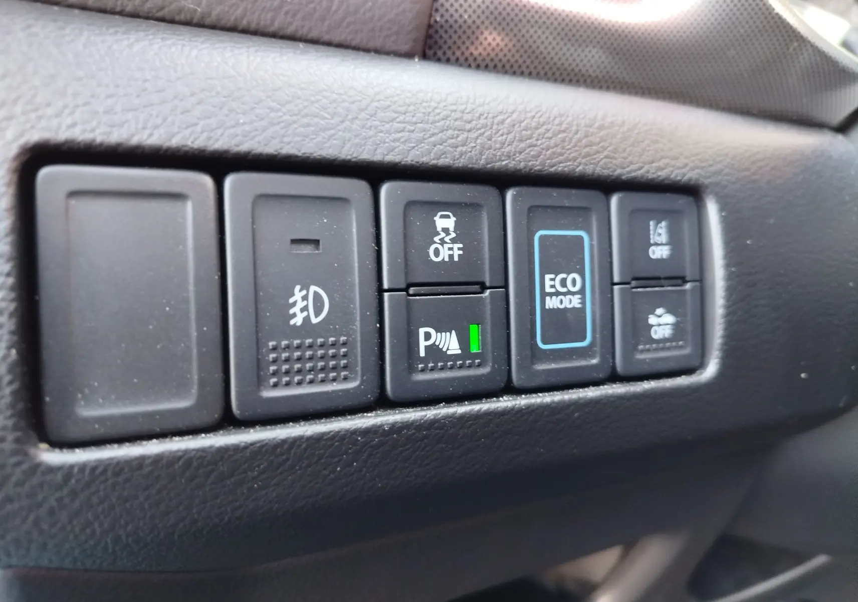 Gros plan sur les boutons de commande intérieurs du Suzuki Vitara hybride, avec le bouton Eco Mode bien visible.