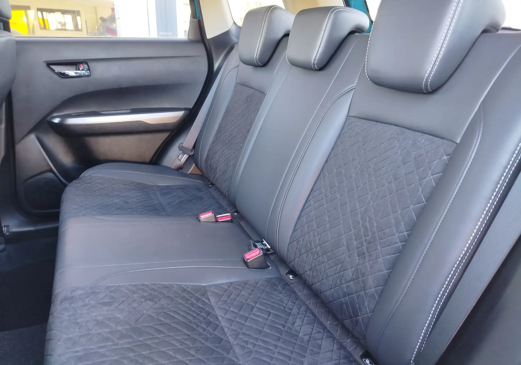 Vue intérieure côté droit des sièges arrière en cuir noir et tissu matelassé du Suzuki Vitara 1.5 Hybrid 2023.