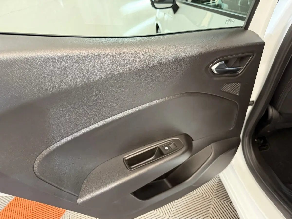 Vue intérieure de la porte arrière droite noire d'une Renault Clio blanche Business TCe 100 GPL 2023, avec poignée et commande de vitre.