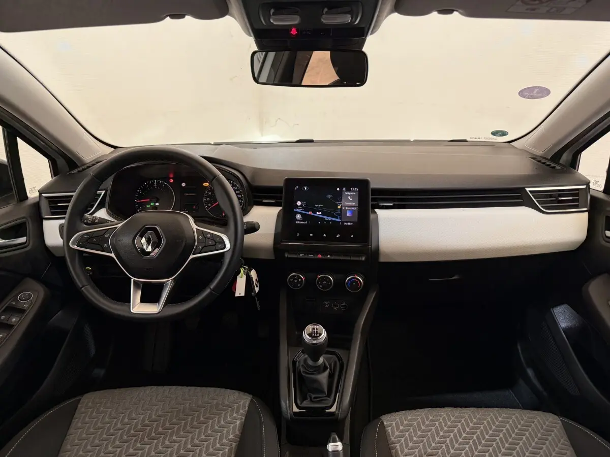 Vue intérieure avant de la Renault Clio Business TCe 100 GPL 2023, volant cuir, écran tactile central et boîte manuelle.