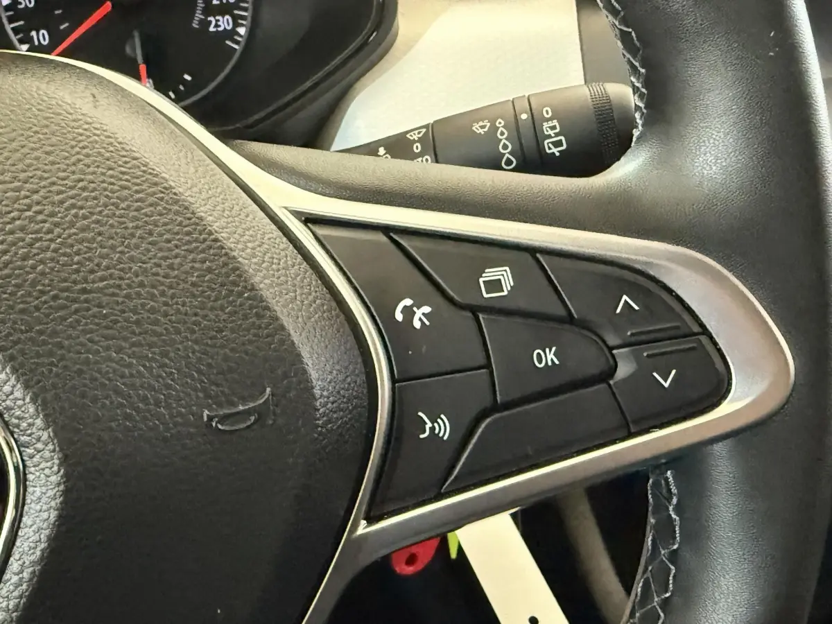 Gros plan sur les commandes multifonctions à droite du volant cuir noir de la Renault Clio Business TCe 100 GPL 2023.