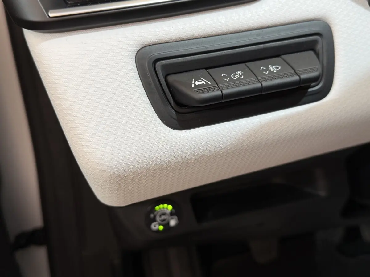 Détail du panneau de commandes blanc côté conducteur de la Renault Clio Business TCe 100 GPL 2023 avec réglages d'assistance et éclairage.