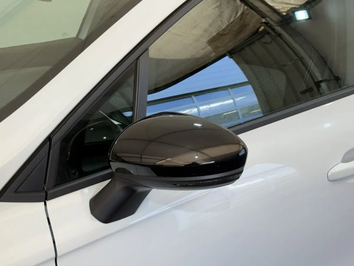 Rétroviseur noir côté conducteur sur Renault Clio Business blanc, vue rapprochée du côté gauche avant.