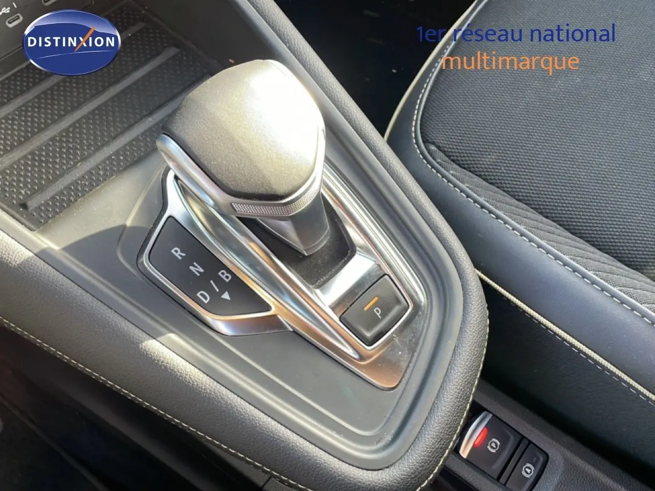 Gros plan sur le levier de vitesses automatique et la console centrale avec sellerie noire de la Renault Symbioz gris Cassiopée.