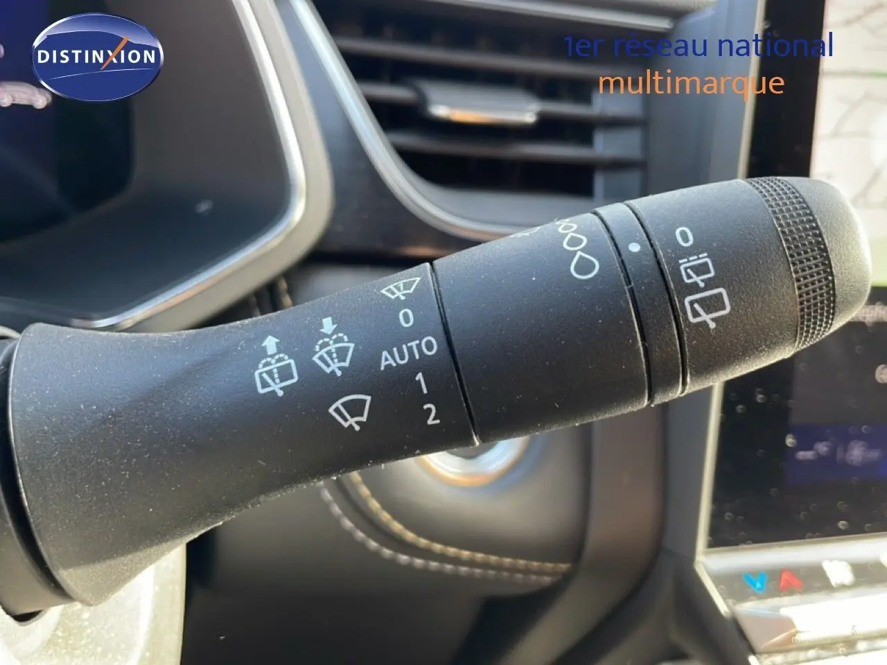 Gros plan sur la commande d'essuie-glace du Renault Symbioz gris Cassiopée, avec détails des symboles et commandes visibles.