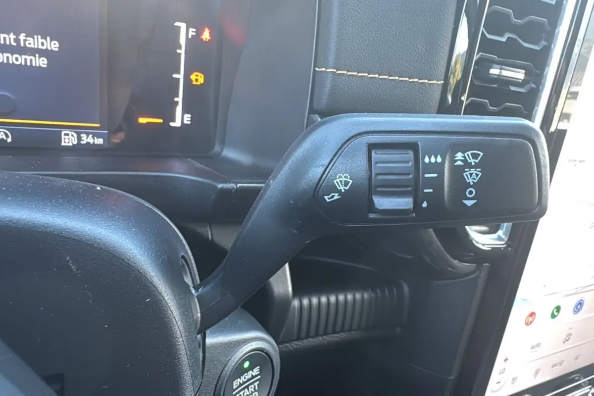 Gros plan sur la commande d’essuie-glace noire à gauche du volant dans l’habitacle du Ford Ranger gris carbone 2025.